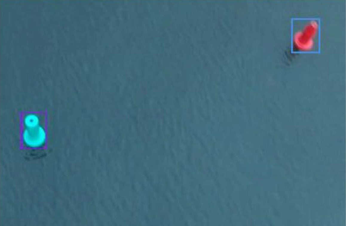 Drone camera view of a green and a red buoy on the water, each inside a detection box